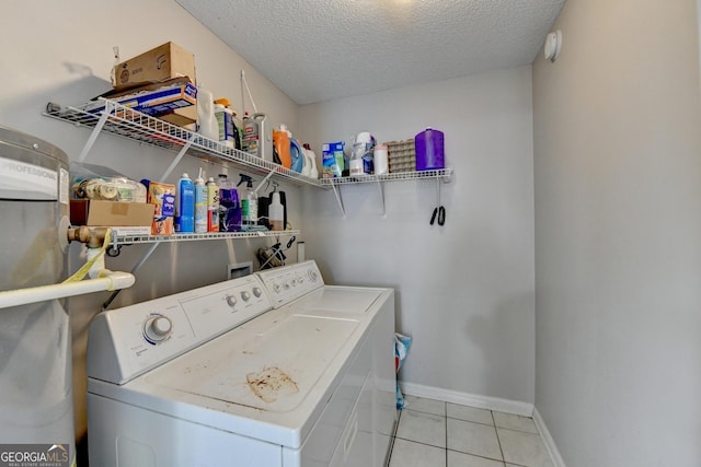 laundry room with washer and clothes dryer, a textured ceiling, and light tile patterned floors