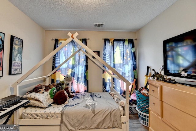 bedroom with hardwood / wood-style flooring and a textured ceiling