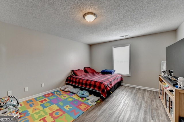 bedroom featuring hardwood / wood-style floors and a textured ceiling