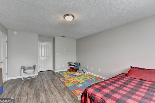 bedroom featuring wood-type flooring and a textured ceiling