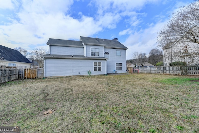 rear view of house featuring a yard