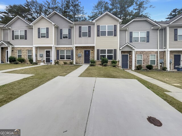 townhome / multi-family property with a front yard