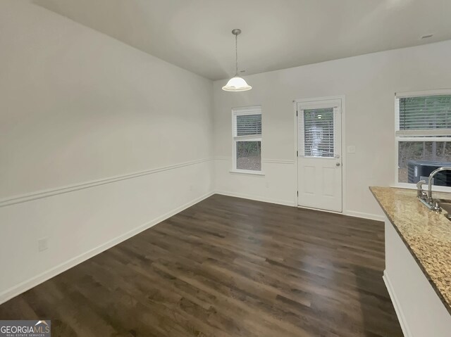 unfurnished dining area featuring sink and dark hardwood / wood-style floors