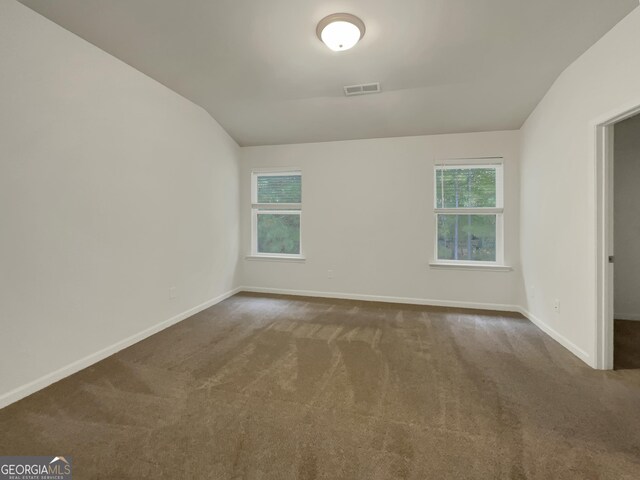 carpeted empty room featuring lofted ceiling