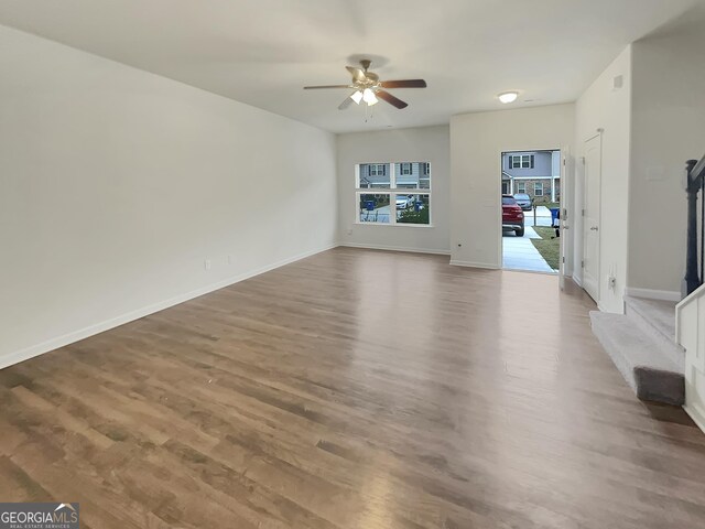 unfurnished living room featuring ceiling fan and hardwood / wood-style floors