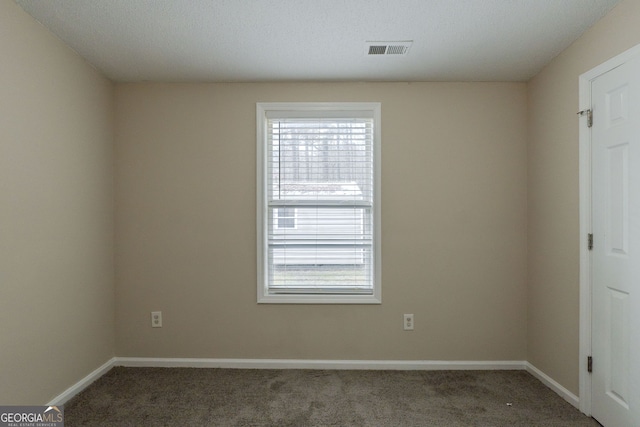 empty room featuring dark colored carpet