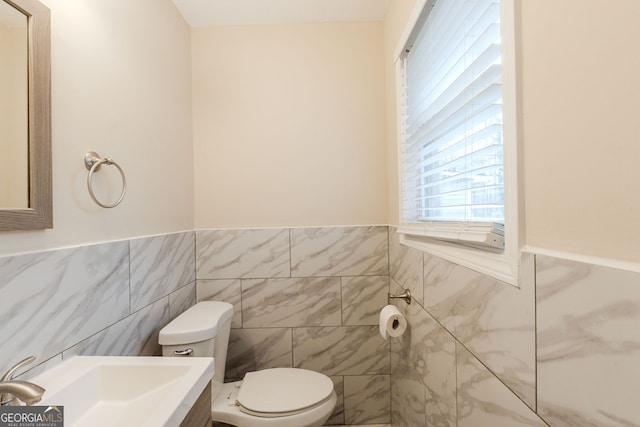 bathroom with sink, tile walls, and toilet