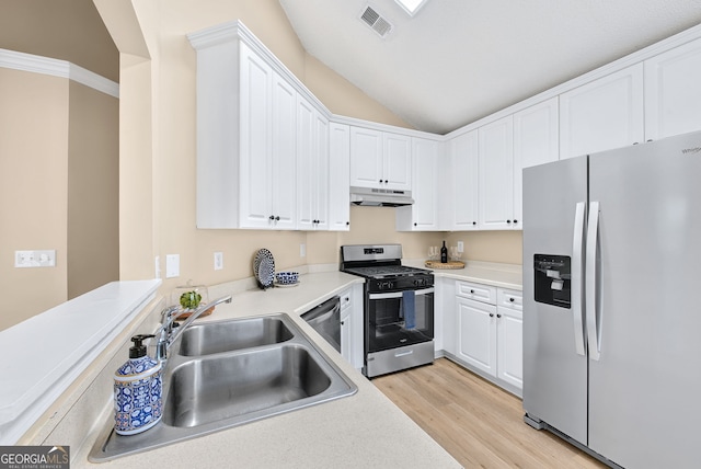 kitchen with lofted ceiling, sink, appliances with stainless steel finishes, white cabinetry, and light wood-type flooring