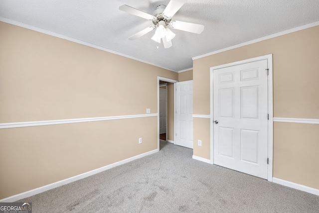 unfurnished bedroom featuring crown molding, light colored carpet, ceiling fan, and a textured ceiling