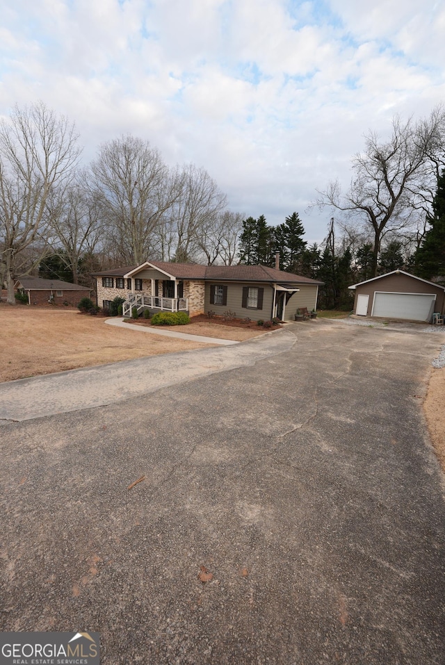 ranch-style house with an outbuilding, a garage, and a porch