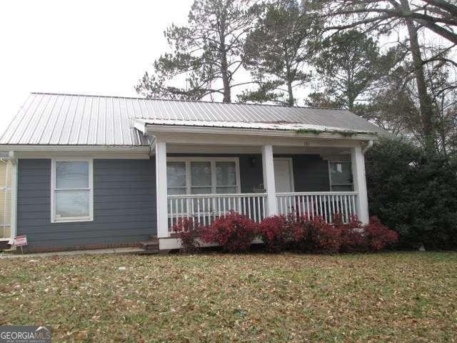 view of front of property featuring covered porch and a front lawn