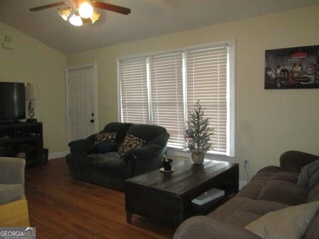 living room featuring dark wood-type flooring, ceiling fan, and vaulted ceiling