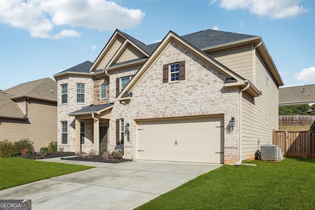 craftsman house featuring driveway, a front lawn, central AC, fence, and a garage