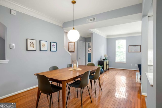 dining area featuring hardwood / wood-style floors and crown molding