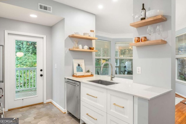 kitchen featuring white cabinetry, plenty of natural light, dishwasher, and sink