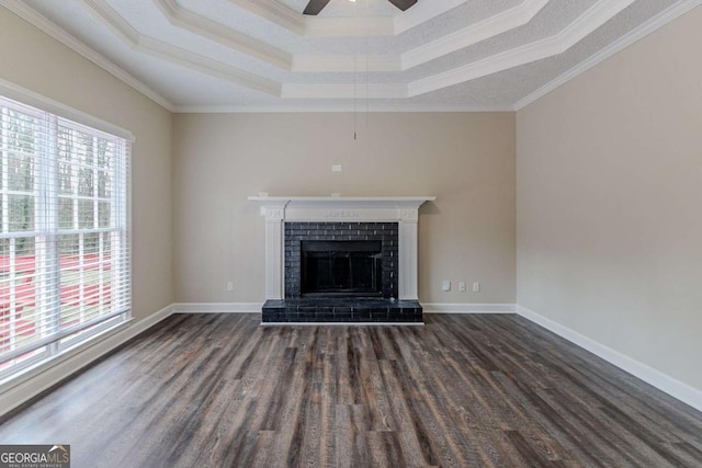 unfurnished living room with dark wood-type flooring, a fireplace, a tray ceiling, and ceiling fan