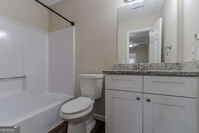 full bathroom featuring hardwood / wood-style floors, vanity, toilet, tub / shower combination, and a textured ceiling