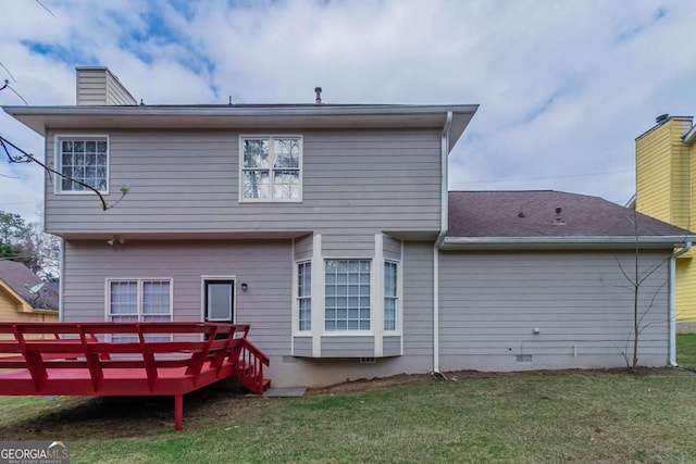 rear view of property with a deck and a lawn