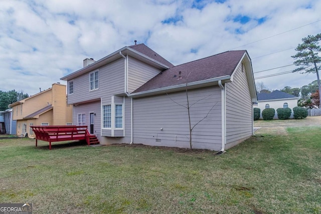 rear view of house with a lawn and a deck