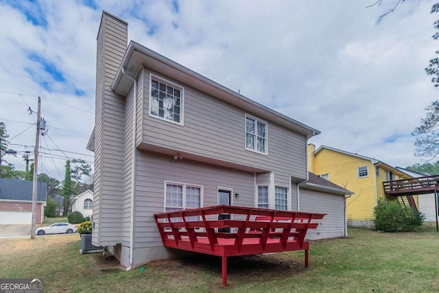 rear view of property with a yard and a deck