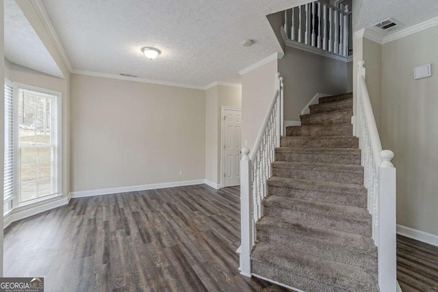 stairs featuring ornamental molding, wood-type flooring, and a textured ceiling