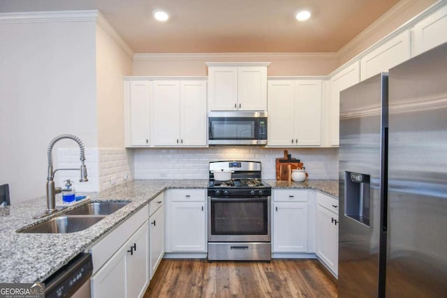 kitchen featuring sink, crown molding, white cabinetry, stainless steel appliances, and light stone countertops