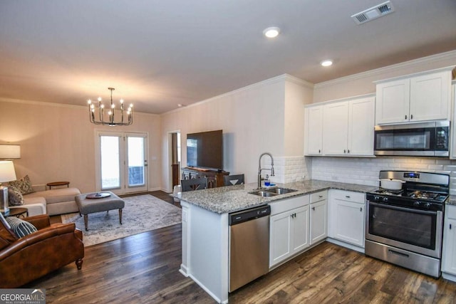 kitchen with light stone counters, sink, stainless steel appliances, and white cabinets