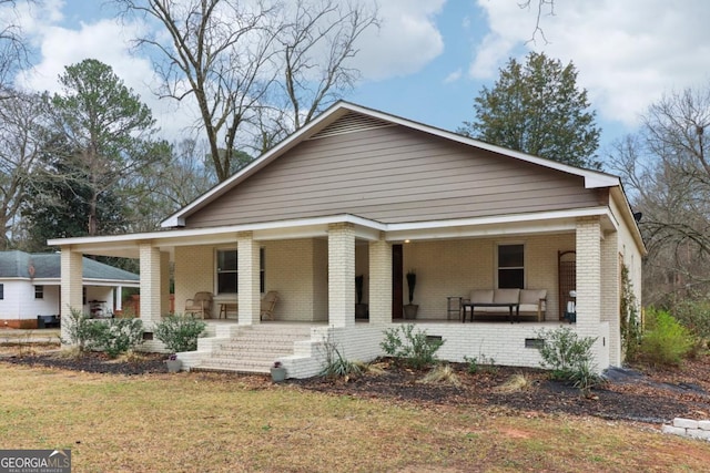 bungalow with a porch and a front lawn