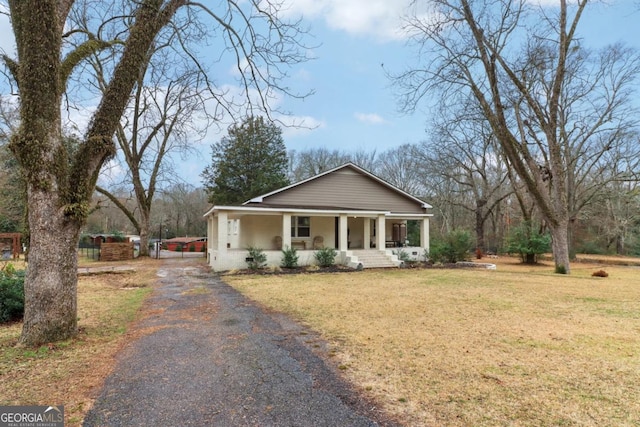 bungalow-style home with a front yard and covered porch