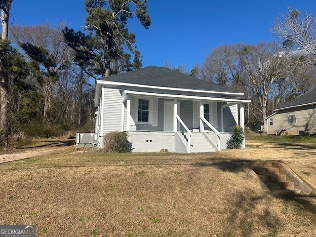 view of front facade with a front yard and covered porch