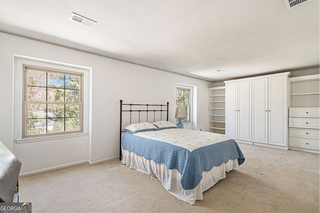 bedroom featuring visible vents, light carpet, and baseboards