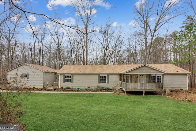 back of property featuring a deck and a lawn