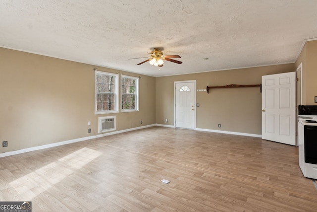 unfurnished living room with a wall mounted air conditioner, a textured ceiling, ceiling fan, and light hardwood / wood-style flooring