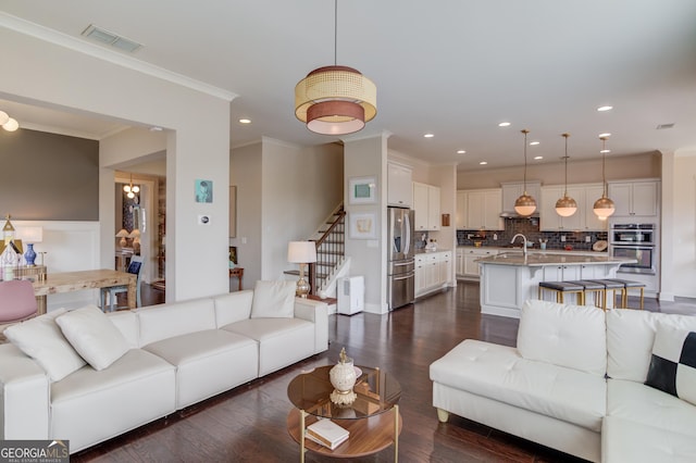 living room featuring ornamental molding, dark hardwood / wood-style floors, and sink