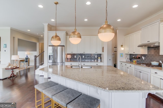 kitchen with stainless steel appliances, decorative light fixtures, sink, and white cabinets