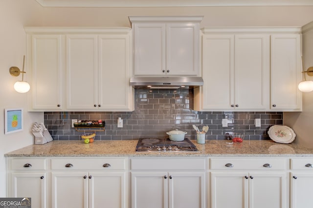 kitchen with light stone counters, stainless steel gas cooktop, and white cabinets