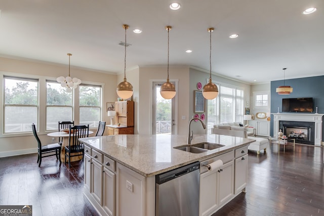 kitchen featuring sink, white cabinets, stainless steel dishwasher, light stone countertops, and a center island with sink