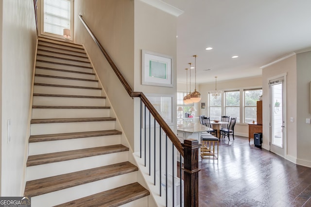 staircase featuring crown molding and wood-type flooring