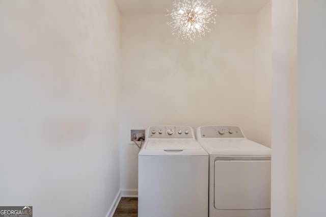 washroom featuring washing machine and dryer and an inviting chandelier