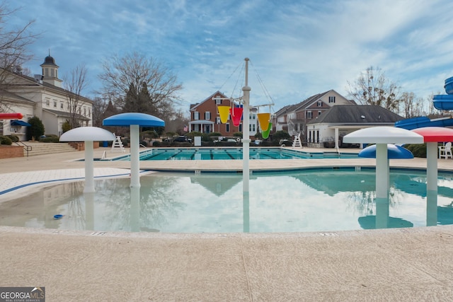 view of swimming pool featuring a water slide and a patio area