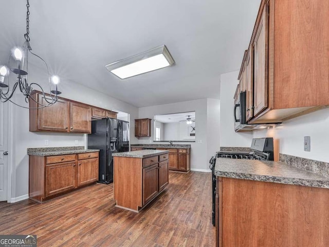 kitchen featuring sink, dark hardwood / wood-style floors, black appliances, a kitchen island, and ceiling fan with notable chandelier