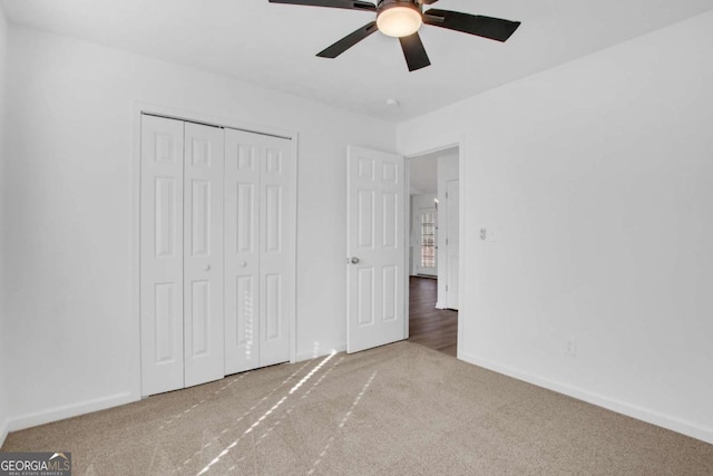 unfurnished bedroom with ceiling fan, carpet floors, and a closet