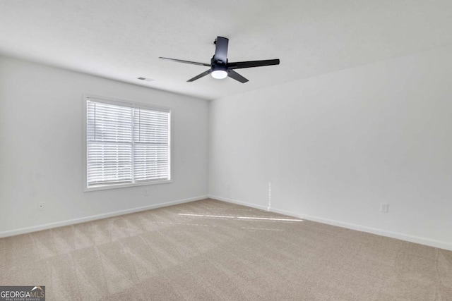 empty room featuring light colored carpet and ceiling fan