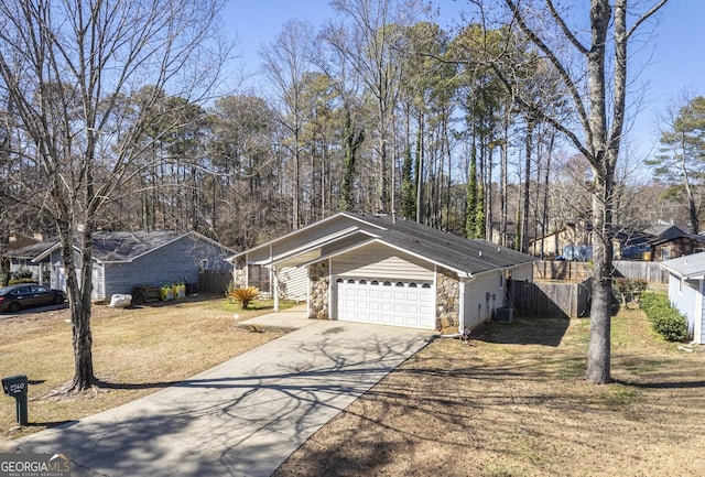 single story home featuring a garage, cooling unit, and a front yard