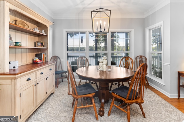 dining area featuring crown molding, light hardwood / wood-style floors, and a chandelier