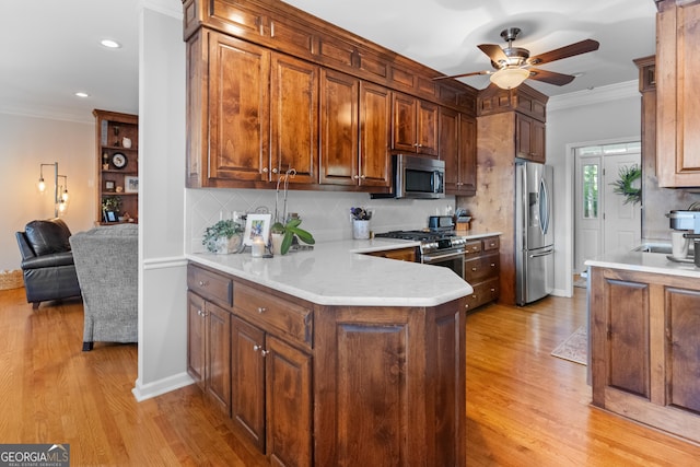 kitchen featuring tasteful backsplash, ornamental molding, appliances with stainless steel finishes, and kitchen peninsula