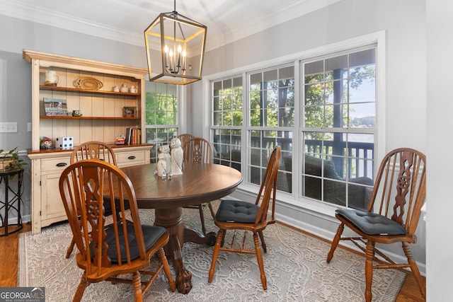 dining area with crown molding, a chandelier, and light hardwood / wood-style floors