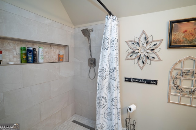 bathroom featuring vaulted ceiling and a shower with shower curtain