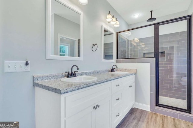 bathroom featuring wood-type flooring, an enclosed shower, and vanity