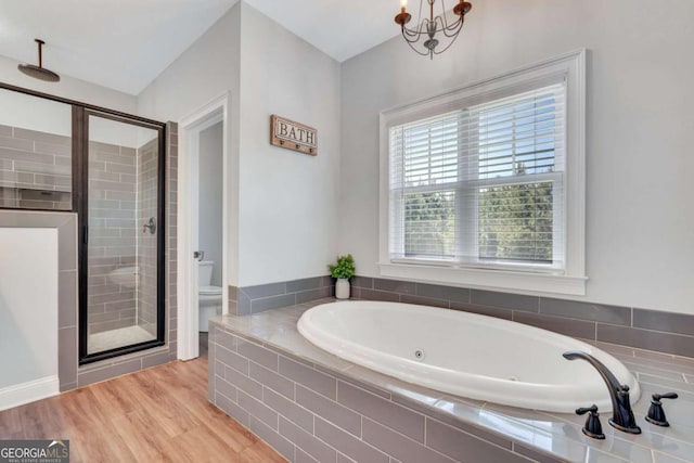 bathroom featuring toilet, a chandelier, hardwood / wood-style floors, and shower with separate bathtub